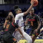 
              James Madison guard Kiki Jefferson (30) navigates between Maryland guards Katie Benzan (11) and Shyanne Sellers (0) during the first half of an NCAA college basketball game in Harrisonburg, Va., Sunday, Nov. 14, 2021. (Daniel Lin/Daily News-Record via AP)
            