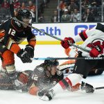 
              Anaheim Ducks' Josh Manson, center, falls to the ice while chasing the puck with New Jersey Devils' Dawson Mercer, right, during the first period of an NHL hockey game Tuesday, Nov. 2, 2021, in Anaheim, Calif. (AP Photo/Jae C. Hong)
            