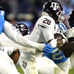 
              Texas A&M running back Isaiah Spiller (28) has his jersey pulled by a Mississippi defender during the first half of an NCAA college football game, Saturday, Nov. 13, 2021, in Oxford, Miss. (AP Photo/Rogelio V. Solis)
            