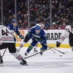 
              Vancouver Canucks' Bo Horvat (53) stickhandles past Chicago Blackhawks' Alex DeBrincat, right, during the second period of an NHL hockey game in Vancouver, British Columbia, Sunday, Nov. 21, 2021. (Darryl Dyck/The Canadian Press via AP)
            