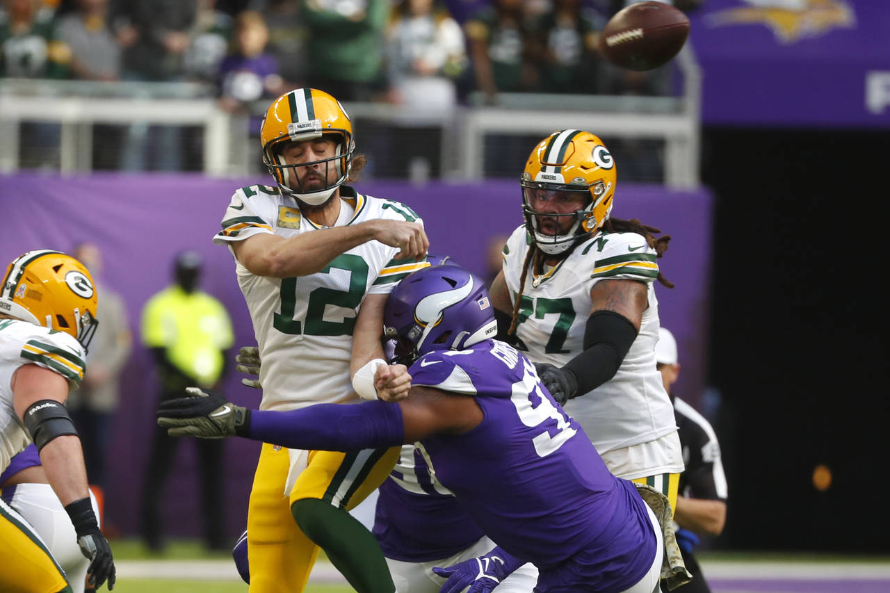 Green Bay Packers quarterback Aaron Rodgers (12) passes as he is hit by Minnesota Vikings defensive...