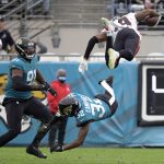 
              Atlanta Falcons wide receiver Russell Gage, top right, leaps over Jacksonville Jaguars cornerback Tyson Campbell (32) and defensive end Dawuane Smoot, left, after a reception during the first half of an NFL football game, Sunday, Nov. 28, 2021, in Jacksonville, Fla. (AP Photo/Phelan M. Ebenhack)
            