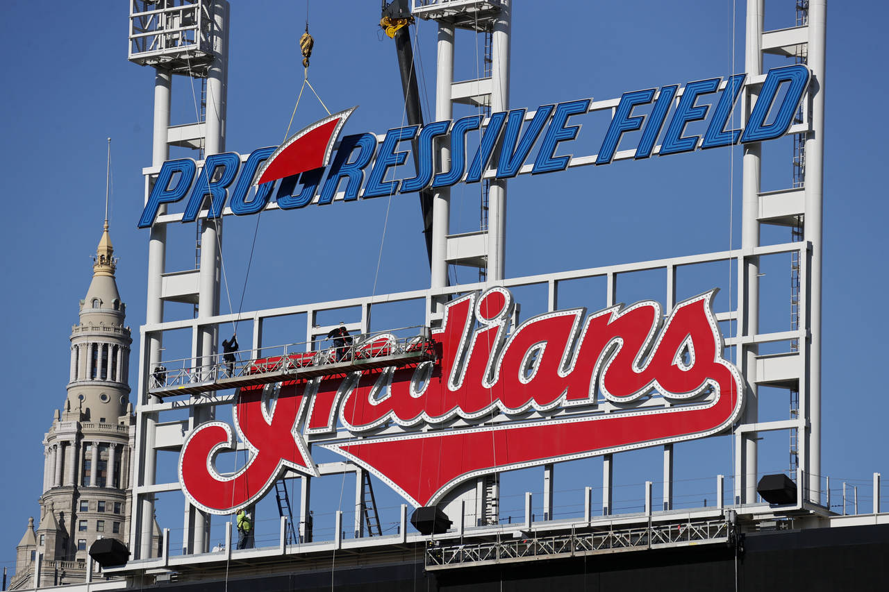 Workers begin to remove the Cleveland Indians sign from above the scoreboard at Progressive Field, ...