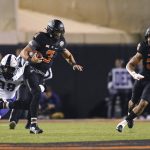 
              Oklahoma State wide receiver Blaine Green (28) rushes to help quarterback Spencer Sanders (3) as TCU defensive end as Dylan Horton (98) reaches for Sanders during the first half of an NCAA college football game Saturday, Nov. 13, 2021, in Stillwater, Okla. (AP Photo/Brody Schmidt)
            