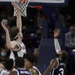 
              Dixie State guard Cameron Gooden, right, shoots next to Gonzaga forward Drew Timme, left, during the first half of an NCAA college basketball game, Tuesday, Nov. 9, 2021, in Spokane, Wash. (AP Photo/Young Kwak)
            