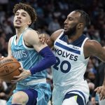 
              Charlotte Hornets guard LaMelo Ball (2) drives to the basket while guarded by Minnesota Timberwolves forward Josh Okogie (20) during the first half of an NBA basketball game in Charlotte, N.C., Friday, Nov. 26, 2021. (AP Photo/Jacob Kupferman)
            