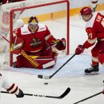 
              Amur's Danil Faizullin, left, tries to score against Kunlun Red Star's goalie Jeremy Smith, center, as Kunlun Red Star's Cory Kane, right, tries to block during the Kontinental Hockey League ice hockey match between Kunlun Red Star Beijing and Amur Khabarovsk in Mytishchi, just outside Moscow, Russia, Monday, Nov. 15, 2021. Many of Kunlun Red Star's players are aiming to represent the Chinese national team at the Olympics in Beijing. (AP Photo/Alexander Zemlianichenko)
            