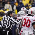 
              Referees separate Ohio State players from the Michigan players during the second half of an NCAA college football game, Saturday, Nov. 27, 2021, in Ann Arbor, Mich. (AP Photo/Carlos Osorio)
            
