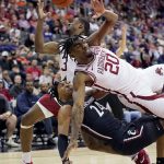 
              Arkansas' Kamani Johnson (20) and Trey Wade (3) collide with Cincinnati's Jeremiah Davenport (24) as they chase a loose ball during the first half of an NCAA college basketball game Tuesday, Nov. 23, 2021, in Kansas City, Mo. (AP Photo/Charlie Riedel)
            