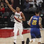 
              Portland Trail Blazers guard CJ McCollum, left, reacts after making a 3 point shot as Denver Nuggets guard Austin Rivers, left, runs back downcourt during the first half of an NBA basketball game in Portland, Ore., Tuesday, Nov. 23, 2021. (AP Photo/Steve Dipaola)
            