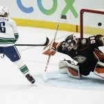 
              Anaheim Ducks goaltender John Gibson, right, deflects the puck hit by Vancouver Canucks' Brock Boeser during the second period of an NHL hockey game Sunday, Nov. 14, 2021, in Anaheim, Calif. (AP Photo/Jae C. Hong)
            