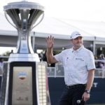 
              Jason Kokrak waves to the gallery while standing near the trophy during ceremonies after winning the Houston Open golf tournament Sunday, Nov. 14, 2021, in Houston. (AP Photo/Michael Wyke)
            
