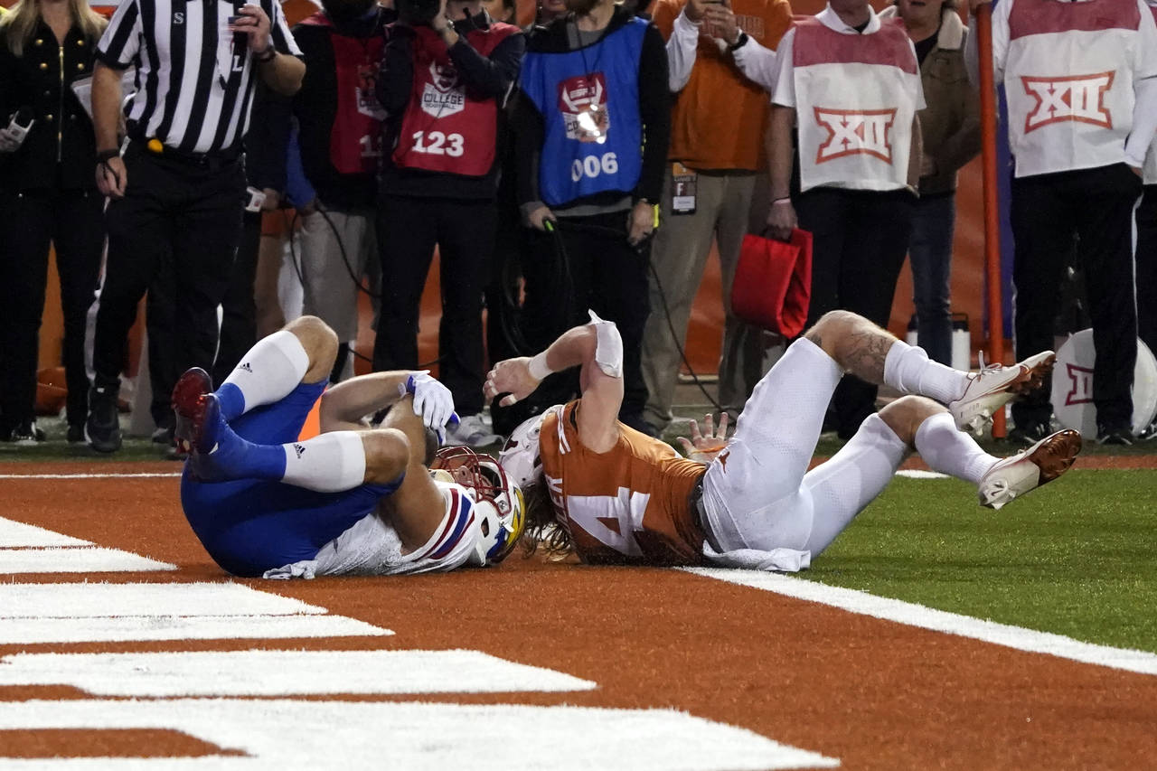 Kansas fullback Jared Casey, left, catches a 2-point conversion past Texas defensive back Brenden S...