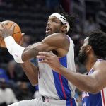 
              Detroit Pistons forward Jerami Grant, defense by Philadelphia 76ers center Joel Embiid makes a layup during the first half of an NBA basketball game, Thursday, Nov. 4, 2021, in Detroit. (AP Photo/Carlos Osorio)
            