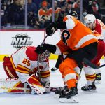 
              Philadelphia Flyers' Zack MacEwen (17) tries to pry the puck loose from Calgary Flames' Jacob Markstrom (25) during the second period of an NHL hockey game, Tuesday, Nov. 16, 2021, in Philadelphia. (AP Photo/Matt Slocum)
            