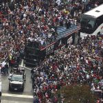 
              Atlanta Braves players hoist the Commissioner's Trophy from the top of a double decker bus while surrounded by fans as they arrive in the Battery outside Truist Park while the team hosts a World Series championship parade and celebration on Friday, Nov. 5, 2021, in Atlanta. (Curtis Compton/Atlanta Journal-Constitution via AP)
            