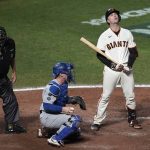 
              San Francisco Giants' Buster Posey, right, reacts after striking out next to Los Angeles Dodgers catcher Will Smith, middle, and umpire Doug Eddings (88) during the eighth inning of Game 5 of a baseball National League Division Series Thursday, Oct. 14, 2021, in San Francisco. (AP Photo/Eric Risberg)
            
