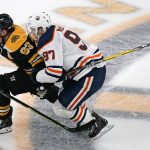 
              Edmonton Oilers center Connor McDavid (97) hangs on to Boston Bruins center Brad Marchand (63) while chasing the puck during the third period of an NHL hockey game Thursday, Nov. 11, 2021, in Boston. (AP Photo/Charles Krupa)
            