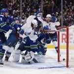 
              Colorado Avalanche's Nazem Kadri (91) scores against Vancouver Canucks goalie Thatcher Demko (35) and is checked into the net by J.T. Miller (9) during the third period of an NHL hockey game Wednesday, Nov. 17, 2021, in Vancouver, British Columbia. (Darryl Dyck/The Canadian Press via AP
            