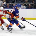 
              New York Islanders right wing Oliver Wahlstrom (26) controls the puck in front of Calgary Flames center Sean Monahan in the second period of an NHL hockey game Saturday, Nov. 20, 2021, in Elmont, N.Y. (AP Photo/Adam Hunger)
            