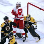 
              Detroit Red Wings' Michael Rasmussen (27) deflects a shot in front of Boston Bruins' Linus Ullmark, right, during the second period of an NHL hockey game Tuesday, Nov. 30, 2021, in Boston. (AP Photo/Michael Dwyer)
            