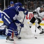 
              Los Angeles Kings left wing Phillip Danault, right, passes the puck from behind the net past Toronto Maple Leafs center Auston Matthews, left, during the second period of an NHL hockey game in Los Angeles, Wednesday, Nov. 24, 2021. (AP Photo/Alex Gallardo)
            