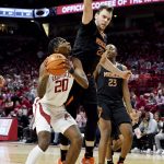 
              Arkansas forward Kamani Johnson (20) tries to drive past Mercer defenders Felipe Haase (22) James Glisson III (23) during the first half of an NCAA college basketball game Tuesday Nov. 9, 2021, in Fayetteville, Ark. (AP Photo/Michael Woods)
            