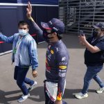 
              Red Bull driver Sergio Perez, of Mexico, greets fans from outside the paddock during the Formula One Mexico Grand Prix auto race at the Hermanos Rodriguez racetrack in Mexico City, Sunday, Nov. 7, 2021. (AP Photo/Eduardo Verdugo)
            