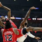 
              Chicago Bulls forward Derrick Jones Jr. (5) grabs a rebound against Los Angeles Clippers guard Paul George (13) with Bulls guard Ayo Dosunmu (12) looking on during the first half of an NBA basketball game Sunday, Nov. 14, 2021, in Los Angeles. (AP Photo/Alex Gallardo)
            