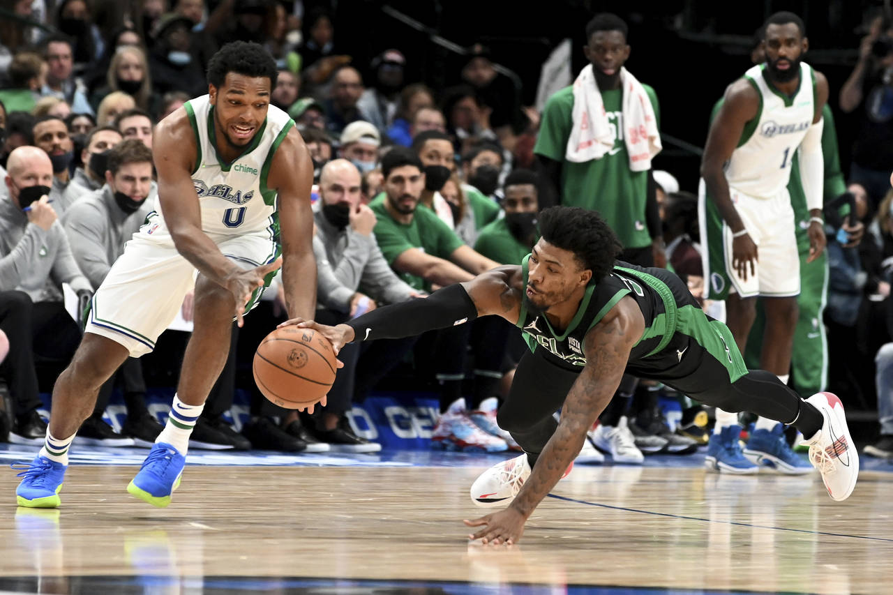 Boston Celtics guard Marcus Smart, right, goes for the steal on Dallas Mavericks forward Sterling B...
