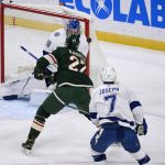 
              Minnesota Wild center Nick Bjugstad, center, hits the puck over the shoulder of Tampa Bay Lightning goalie Andrei Vasilevskiy to score as Lightning right wing Mathieu Joseph looks on during the first period of an NHL hockey game Sunday, Nov. 28, 2021, in St. Paul, Minn. (AP Photo/Craig Lassig)
            