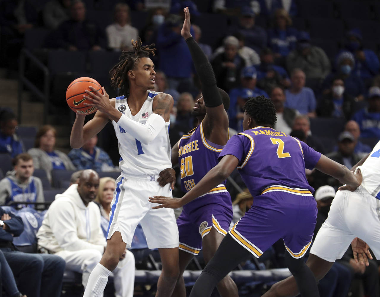 Tennessee Tech's John Pettway center, defends as Memphis Emoni Bates looks for an outlet in the fir...