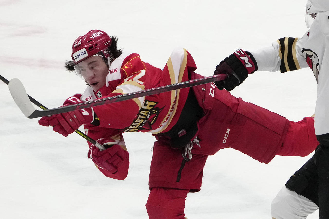 Kunlun Red Star's Parker Foo battles for the puck during the Kontinental Hockey League ice hockey m...