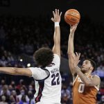 
              Texas forward Timmy Allen (0) shoots while pressured by Gonzaga forward Anton Watson (22) during the first half of an NCAA college basketball game, Saturday, Nov. 13, 2021, in Spokane, Wash. (AP Photo/Young Kwak)
            