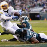 
              Los Angeles Chargers wide receiver Keenan Allen (13) is brought down with the ball by Philadelphia Eagles defensive back Andre Chachere (21) and Philadelphia Eagles cornerback Darius Slay (2) during the first half of an NFL football game on Sunday, Nov. 7, 2021, in Philadelphia. (AP Photo/Matt Rourke)
            