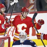 
              Calgary Flames' Elias Lindholm, left, celebrates his goal against the Winnipeg Jets with Johnny Gaudreau, center, and Sean Monahan during the first period of an NHL hockey game Saturday, Nov. 27, 2021, in Calgary, Alberta. (Larry MacDougal/The Canadian Press via AP)
            