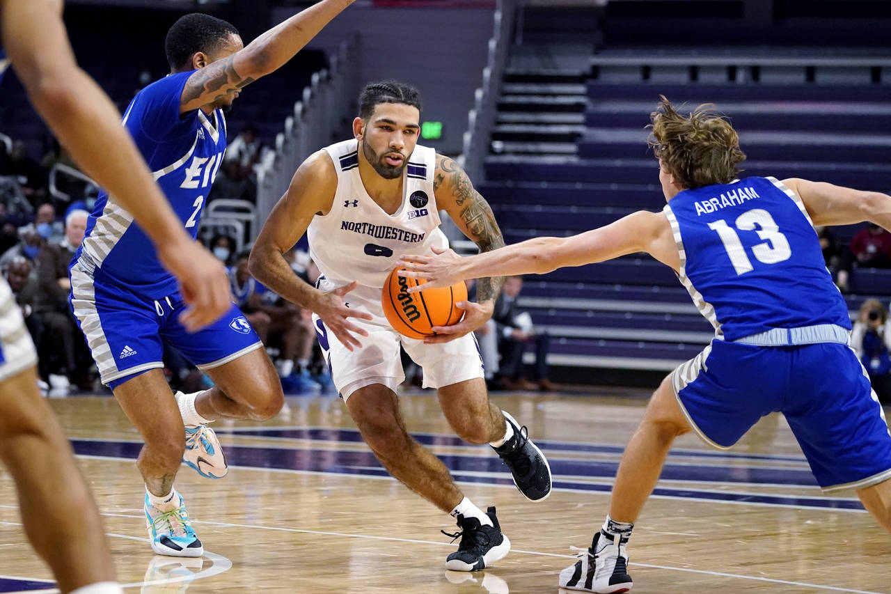Northwestern guard Boo Buie, center, drives against Eastern Illinois guard Myles Baker, left, and g...