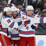 
              New York Rangers' Dryden Hunt, center, is congratulated by Artemi Panarin (10) and Adam Fox after scoring against the Boston Bruins during the second period of an NHL hockey game Friday, Nov. 26, 2021, in Boston. (AP Photo/Winslow Townson)
            