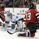 
              San Jose Sharks goaltender James Reimer (47) stops the puck as New Jersey Devils defenseman Ryan Graves (33) and left wing Jesper Bratt (63) look for a rebound during the first period of an NHL hockey game Tuesday, Nov. 30, 2021, in Newark, N.J. (AP Photo/Bill Kostroun)
            