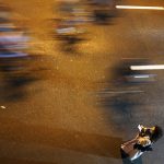 
              In a photograph taken with a slow shutter speed, an organizer watches as bicycles race past her in Dubai, United Arab Emirates, Friday, Nov. 5, 2021. The annual Dubai Ride saw authorities shut down the skyscraper-lined super highway that cuts through the center of the city-state to allow bicyclists to ride on it. Organizers say 32,750 people took part in the ride Friday. (AP Photo/Jon Gambrell)
            