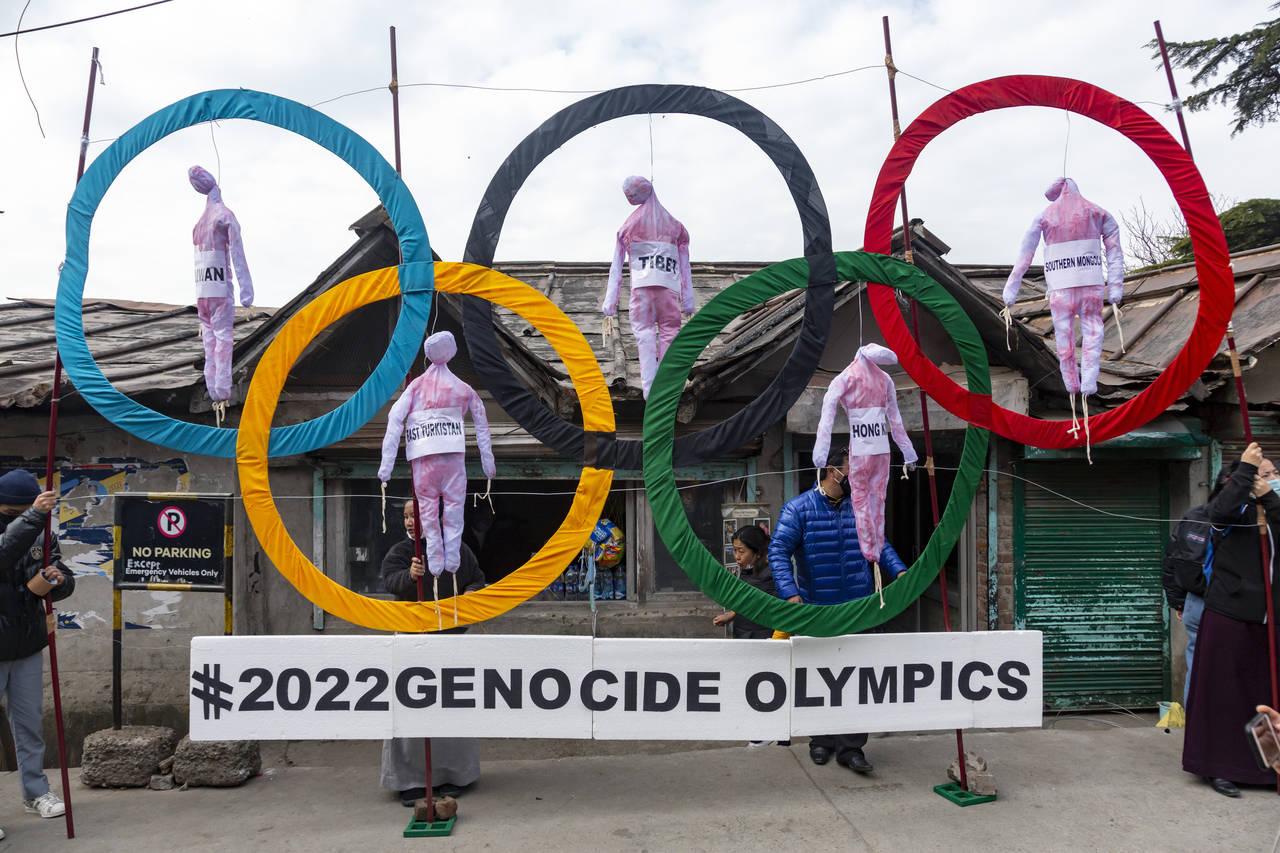 FILE - In this Feb. 3, 2021, file photo, exile Tibetans use the Olympic Rings as a prop as they hol...