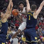 
              UNLV guard Keshon Gilbert (10) looks to pass against as Michigan's Hunter Dickinson, right, and Caleb Houstan defend during the first half of an NCAA college basketball game Friday, Nov. 19, 2021, in Las Vegas. (AP Photo/David Becker)
            