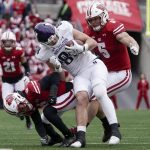 
              Northwestern's Marshall Lang is stopped by Wisconsin's Dean Engram and Leo Chenal after a catch during the first half of an NCAA college football game Saturday, Nov. 13, 2021, in Madison, Wis. (AP Photo/Morry Gash)
            