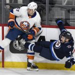 
              Winnipeg Jets' Dylan DeMelo (2) is checked by New York Islanders' Matt Martin (17) during the first period of NHL hockey game action in Winnipeg, Manitoba, Saturday, Nov. 6, 2021. (Fred Greenslade/The Canadian Press via AP)
            