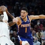 
              Phoenix Suns guard Devin Booker (1) is unable to steal the ball from Denver Nuggets forward Will Barton (5) during the second half of an NBA basketball game Sunday, Nov. 21, 2021, in Phoenix. The Suns won 126-97. (AP Photo/Ross D. Franklin)
            