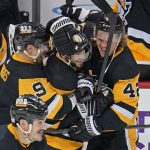 
              Pittsburgh Penguins' Kris Letang, center, celebrates with Kasperi Kapanen (42) and Evan Rodrigues (9) after his overtime winning goal is announced following a review during an NHL hockey game against the Philadelphia Flyers in Pittsburgh, Thursday, Nov. 4, 2021. (AP Photo/Gene J. Puskar)
            