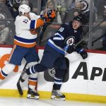 
              Winnipeg Jets' Nate Schmidt (88) avoids a hit by New York Islanders' Matt Martin (17) during the first period of NHL hockey game action in Winnipeg, Manitoba, Saturday, Nov. 6, 2021. (Fred Greenslade/The Canadian Press via AP)
            