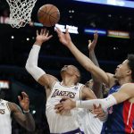 
              Los Angeles Lakers guard Russell Westbrook, center, vies of the ball with Detroit Pistons guard Cade Cunningham, right, during the first half of an NBA basketball game Sunday, Nov. 28, 2021, in Los Angeles. (AP Photo/Alex Gallardo)
            