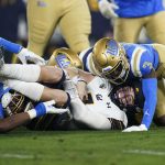 
              California quarterback Chase Garbers, center, is brought down by UCLA defensive back Cameron Johnson, right, and linebacker Mitchell Agude during the first half of an NCAA college football game Saturday, Nov. 27, 2021, in Pasadena, Calif. (AP Photo/Jae C. Hong)
            