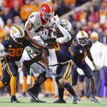 
              Georgia running back Kenny McIntosh (6) leaps as he's hit by Tennessee linebackers Roman Harrison (30) and Jeremy Banks (33) during the second half of an NCAA college football game Saturday, Nov. 13, 2021, in Knoxville, Tenn. against Georgia won 41-17. (AP Photo/Wade Payne)
            